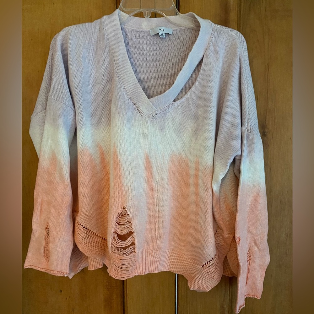 100% cotton sweater. Fade, “ripped” design
